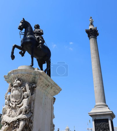 Foto de LONDRES REINO UNIDO - 06 19 2023: La estatua del rey Carlos I con la magnífica Columna Nelsons en el fondo en Trafalgar Square, Londres - Imagen libre de derechos