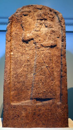 Foto de LONDRES REINO UNIDO 06 17 2023: Estela de piedra caliza de Ashurnasirpal II: tallada; el rey lleva el sombrero real con una parte superior cónica y sostiene una maza que simboliza la autoridad - Imagen libre de derechos