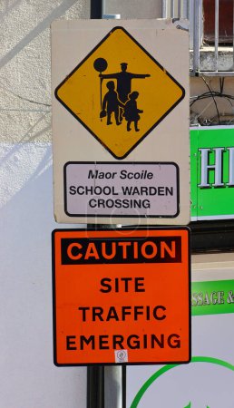 Foto de DUBLIN REPUBLIC OF IRELAND 05 28 2023: School wardens (in english and gaellic) is pedestrian or uncontrolled crossing, the wardens stand facing each other on opposite sides of the road. - Imagen libre de derechos