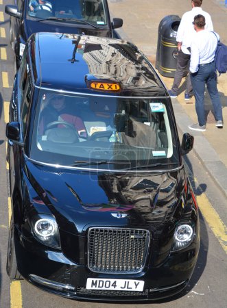 Photo for LONDON UNITED KINGDOM 06 19 2023: "Black cabs" were traditionally coloured black, but this is not a requirement and cabs are painted in other colours, sometimes bearing advertising - Royalty Free Image