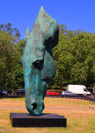 Téléchargez les photos : LONDRES ROYAUME-UNI 06 19 2023 : Still Water, une sculpture en bronze extérieure d'une tête de cheval géante désincarnée capturée comme si le cheval buvait, a été sculptée par l'artiste britannique Nic Fiddian-Green - en image libre de droit