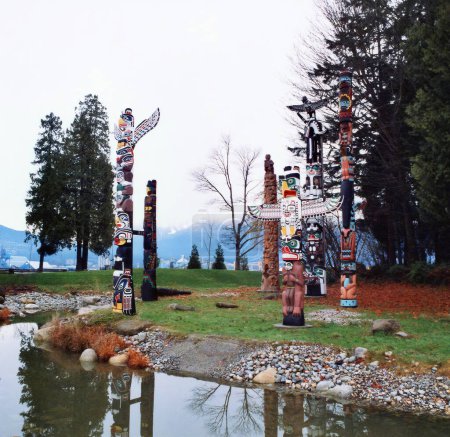Téléchargez les photos : VANCOUVER BC CANADA 12 09 2002 : Les mâts totémiques de Brockton Point dans le parc Stanley sont l'une des attractions touristiques les plus visitées. Les sculptures symbolisent des contes familiers aux Amérindiens - en image libre de droit