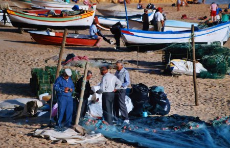 Téléchargez les photos : ALBUFEIRA ALGARVE PORTUGAL 10 22 2002 : Un pêcheur local répare des filets de pieuvre réparateurs - en image libre de droit