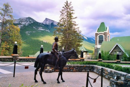 Foto de BANFF ALBERTA CANADA 06 22 03: Estatua de Mountie en el Fairmont Banff Springs Hotel placa cercana menciona la policía montada del noroeste. La Fuerza fue renombrada posteriormente a la Real Policía Montada Canadiense. - Imagen libre de derechos