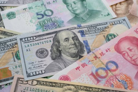 Téléchargez les photos : Fermez les billets en yuans et en dollars. Le concept de la guerre commerciale entre la Chine et les États-Unis - en image libre de droit