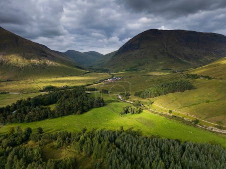 Vista aérea de las montañas con hierba verde y bosque en Auch, Puente de Orchy, Highlands escocés
