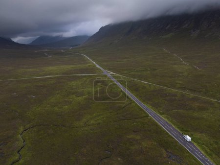 Aerial view of the A82 road with a motorhome passing through the mountains of Glencoe and Glen Etive in the Scottish highlands
