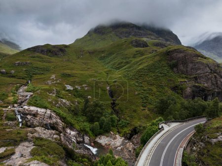 The A82 road passing through The Meeting of Three Waters in Glencoe. Glencoe's Three Sisters Mountains in the background