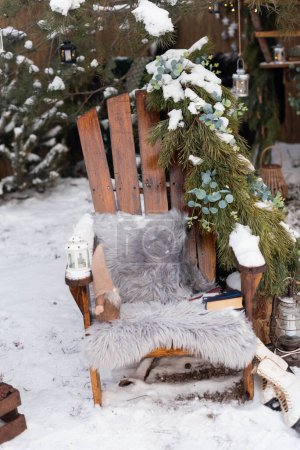 Foto de Silla de madera con cojín de piel con corona de pino grande en el patio trasero - Imagen libre de derechos