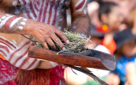 Téléchargez les photos : Cérémonie aborigène australienne, main d'homme avec des branches vertes et une flamme, allumez un feu pour un rite rituel lors d'un événement communautaire à Adélaïde, Australie du Sud - en image libre de droit