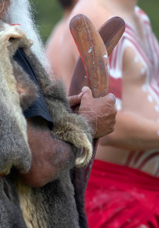 Téléchargez les photos : La main humaine tient des baguettes rituelles pour le rite de bienvenue lors d'un événement communautaire autochtone en Australie - en image libre de droit