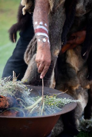 Téléchargez les photos : Main humaine avec branche verte d'eucalyptus, fumée et feu, rite rituel de la fumée lors d'un événement communautaire autochtone en Australie - en image libre de droit