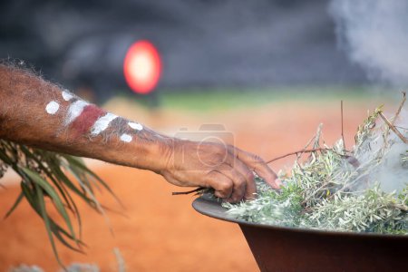 Téléchargez les photos : Main humaine avec branche verte d'eucalyptus, fumée et feu, rite rituel de la fumée lors d'un événement communautaire autochtone en Australie - en image libre de droit