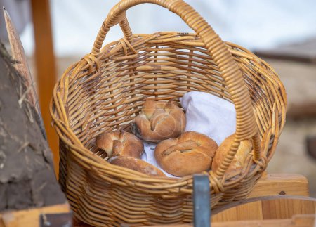 petits pains fraîchement cuits se trouvent dans un panier en osier, pain frais, nature morte. Photo de haute qualité