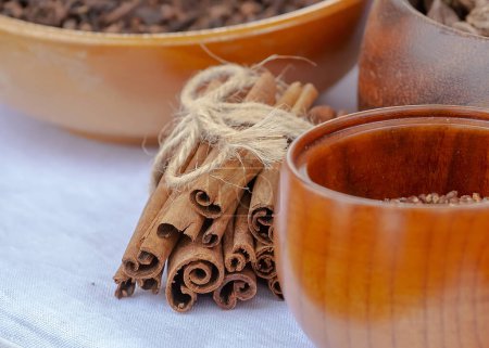 Wooden bowls with spices, cinnamon,close up, ceramics on a wooden table, focus on one bowl, still life. High quality photo