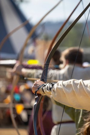 Medieval archery equipment, bow and arrow in the hands of a man. Medieval fair. High quality photo