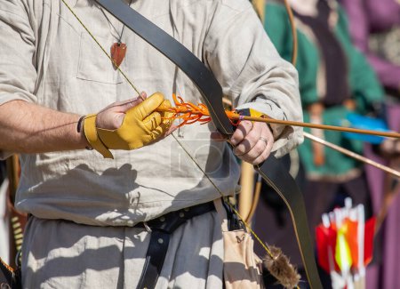 Équipement médiéval de tir à l'arc, arc et flèche dans les mains d'un homme. Foire médiévale. Photo de haute qualité