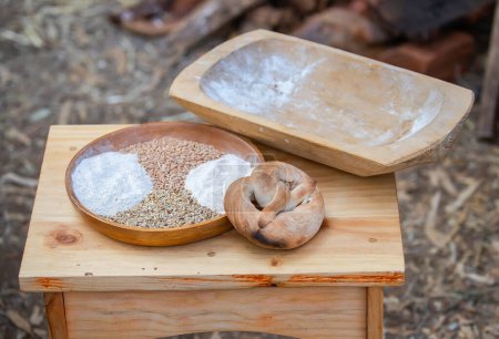 Los panecillos recién horneados yacen sobre una mesa, pan fresco, harina, grano en un tazón, naturaleza muerta. Foto de alta calidad