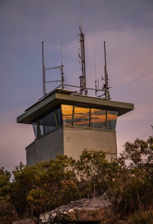 Meteorologischer Turm auf einem Berg im Sonnenuntergang, Himmelsspiegelungen in Fenstern, Grampians National Park, Südaustralien. Hochwertiges Foto