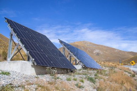 Sonnenkollektoren werden an einem Berghang neben der Straße installiert. Erneuerbare Energien, Umweltprobleme, grüne Technologien. Hochwertiges Foto