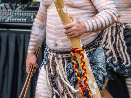 Australian aboriginal ceremony, human hand holds didgeridoo musical tube for the welcome ritual rite at an indigenous reconciliation community event 