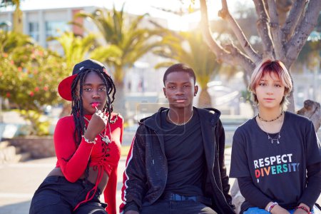 Téléchargez les photos : Portrait trois jeunes latinos adolescents amis assis sur la place de la ville détendue - en image libre de droit