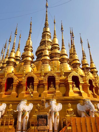 Téléchargez les photos : Pagodes dorées avec statues de bouddha et éléphants au temple bouddhiste Wat Phra That Suthon Mongkhon Khiri à Phrae, nord de la Thaïlande - en image libre de droit