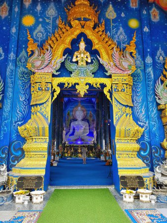 Foto de Entrada a la sala principal del Templo Azul (Wat Rong Sua Ten) en Chiang Rai, Tailandia, con una vista de la estatua gigante de Buda en el templo - Imagen libre de derechos