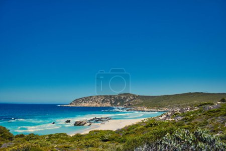Téléchargez les photos : Mer bleue azur, collines rocheuses et végétation côtière basse : West Beach, le long du sentier Hakea dans le parc national de Fitzgerald River, côte sud de l'Australie occidentale. - en image libre de droit
