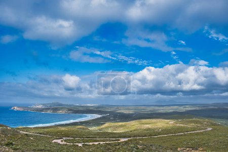 Téléchargez les photos : Vue panoramique de la côte du parc national de Fitzgerald River, côte sud de l'Australie occidentale, depuis le mont Barren. Beaux nuages, baie balayante et longue route - en image libre de droit