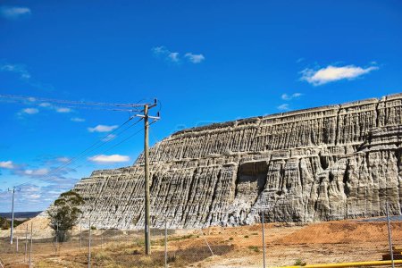 Téléchargez les photos : Le mur de l'immense dépotoir de résidus de la mine d'or Central Norseman à Norseman, en Australie-Occidentale. Les motifs d'érosion sur les murs rappellent un ancien temple - en image libre de droit