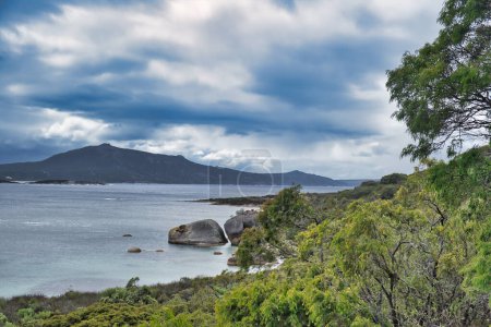 Téléchargez les photos : Paysage côtier préservé le long du sentier du patrimoine dans la réserve naturelle de Two Peoples Bay, près d'Albany, en Australie-Occidentale, par une journée d'été nuageuse - en image libre de droit