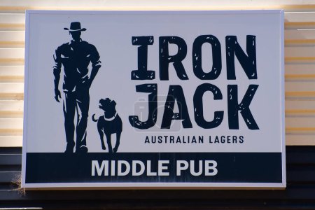 Téléchargez les photos : Homme avec son chien, panneau d'affichage pour Iron Jack Australian Lager sur le mur du Middle Pub à Northampton, Australie occidentale - en image libre de droit