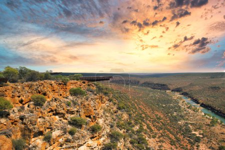 Foto de Puesta de sol ardiente sobre la vasta extensión del desierto del Parque Nacional Kalbarri, Australia Occidental, el Skywalk sobre el cañón del río Murchison a la izquierda. - Imagen libre de derechos