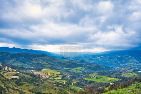 Téléchargez les photos : Vue sur la vallée de la rivière Dhiarizos près du village de Dora, district de Limassol, Chypre, avec des champs et des forêts en terrasses, sous un ciel couvert - en image libre de droit