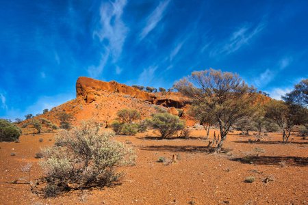 Laterita roja (rocas con hierro y aluminio) formaciones rodeadas de arbusto de sal y mulga en el desierto cerca de Mount Magnet, Australia Occidental.