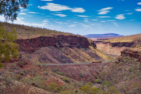 Road train in the Munjini Gorge, the Great Northern Highway in Karijini National Park, Western Australia. The highway winds through a spectacular canyon