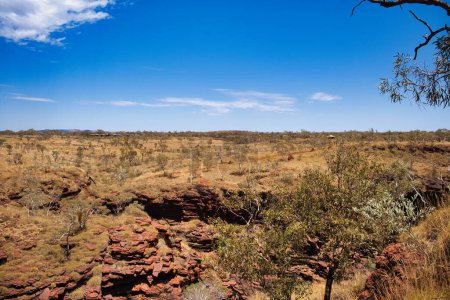 Téléchargez les photos : Paysage de savane à Joffre Gorge, Karijini National Park, Australie-Occidentale. Au loin les bâtiments de l'Eco Retraite. - en image libre de droit