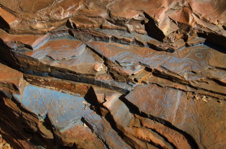Patrones y estructuras azules en capas de formaciones de piedra de hierro con bandas en el Parque Nacional Karijini, en la Cordillera Hamersley, Australia Occidental
