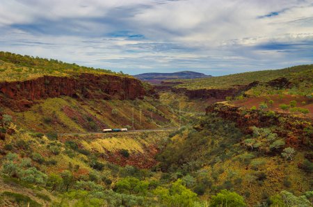 Téléchargez les photos : Train routier sur la Great Northern Highway dans le parc national de Karijini, Australie occidentale. L'autoroute serpente à travers les spectaculaires gorges de Munjina - en image libre de droit