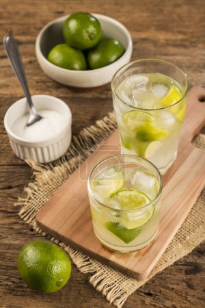 Caipirinha brasileña. Bebida con limón, sobre fondo rústico de madera.