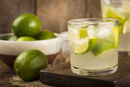 Foto de Caipirinha brasileña. Bebida con limón, sobre fondo rústico de madera. - Imagen libre de derechos