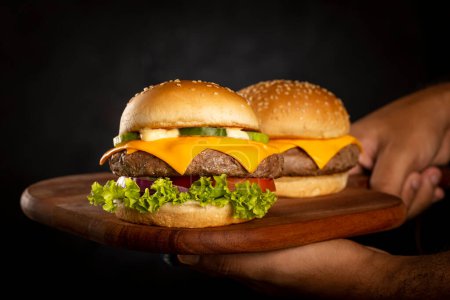 Téléchargez les photos : Burger et cheeseburger sur la planche à découper. - en image libre de droit