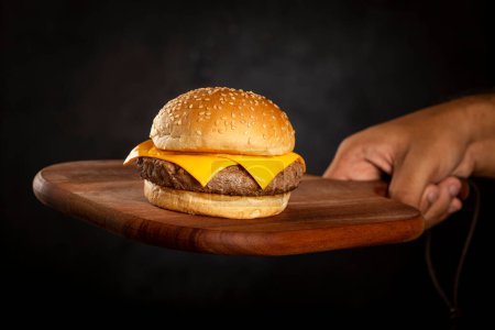 Téléchargez les photos : Cheeseburger sur la planche à découper. - en image libre de droit