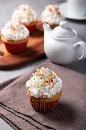 Foto de Sabrosos pastelitos de fiesta sobre la mesa. Cupcakes con crema batida. - Imagen libre de derechos