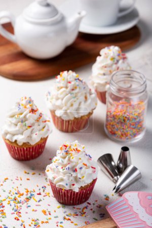 Foto de Sabrosos pastelitos de fiesta sobre la mesa. Cupcakes con crema batida. - Imagen libre de derechos