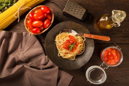 Dish with spaghetti in tomato sauce and basil.