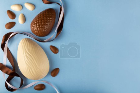 Foto de Semana Santa. Composición con huevos de Pascua de chocolate sobre fondo azul, espacio para texto. - Imagen libre de derechos
