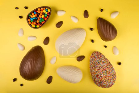Foto de Semana Santa. Composición con huevos de Pascua de chocolate sobre fondo amarillo. - Imagen libre de derechos