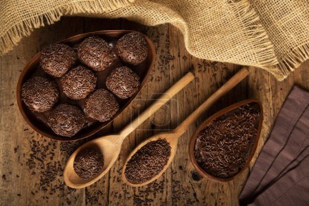 Schokoladen-Osterei gefüllt mit Brigadisten auf Holzgrund.